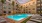 view of the apartment community pool and lounge chairs at night